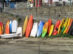 SX09003 Canoes and kayaks lined up against harbour wall.jpg